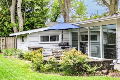a house with a patio with an umbrella at Newly Renovated! Old Homestead Beach Home in Huron