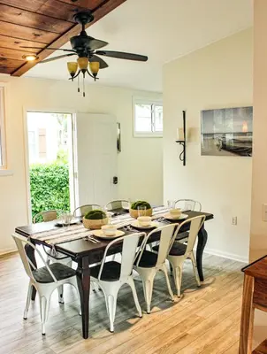 a dining room table with chairs and a ceiling fan at Newly Renovated! Old Homestead Beach Home in Huron