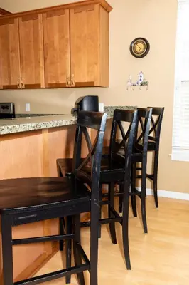 a kitchen with four black chairs at a table at 5 Bedroom Home in Old Homestead II in Huron