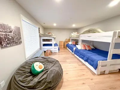 a bedroom with two bunk beds and a large window at Group House Sleeps 26 THE ATTIC - 2 Miles to Cedar Point in Sandusky