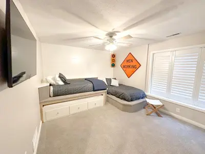 a bedroom with two beds and a tv in it at Group House Sleeps 26 THE ATTIC - 2 Miles to Cedar Point in Sandusky
