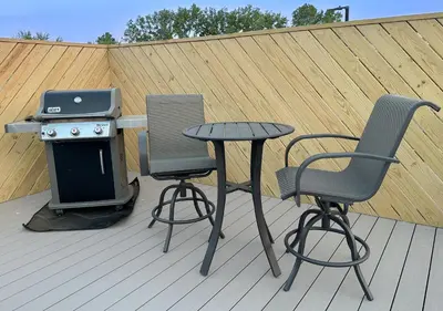 a table and two chairs and a grill on a deck at Group House Sleeps 26 THE ATTIC - 2 Miles to Cedar Point in Sandusky