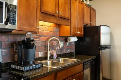a kitchen with a sink and a black refrigerator at Marlin at the Lake - Downtown Sandusky in Sandusky