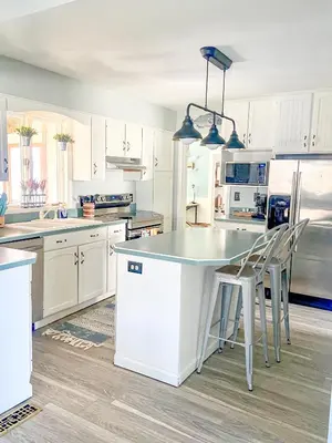 a kitchen with white cabinets and a table and chairs at Historic District Vermilion Home in Vermilion