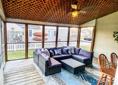 a screened in porch with a couch and a ceiling fan at Historic District Vermilion Home in Vermilion