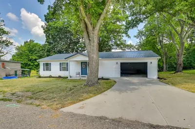 a white garage with a tree in the driveway at Serene Dry Ridge Vacation Rental with Nearby Fishing in Dry Ridge