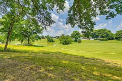 a green field with trees and a path at Serene Dry Ridge Vacation Rental with Nearby Fishing in Dry Ridge