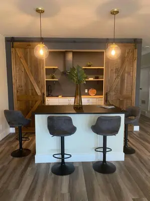 a kitchen with a white island with three bar stools at Modern & Luxurious 1 Bedroom in the Heart of Short North in Columbus