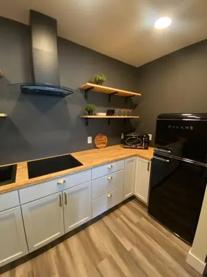 a kitchen with white cabinets and a black refrigerator at Modern & Luxurious 1 Bedroom in the Heart of Short North in Columbus