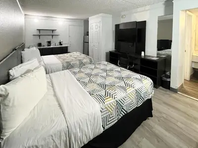 a hotel room with two beds and a flat screen tv at Studio 6 Suites Dayton OH Englewood in Dayton