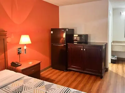 a hotel room with a refrigerator and a bed at Studio 6 Suites Dayton OH Englewood in Dayton