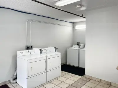 a laundry room with white washers and dryers at Studio 6 Suites Dayton OH Englewood in Dayton