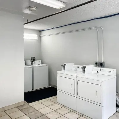 a laundry room with three washers and dryers at Studio 6 Suites Dayton OH Englewood in Dayton