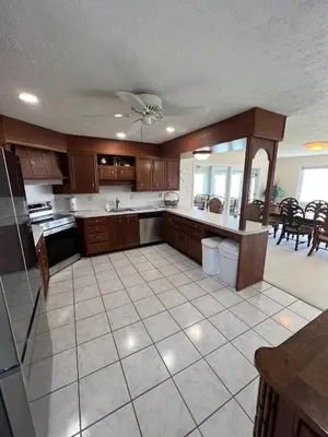 a large kitchen with wooden cabinets and a tile floor at 4 Bedroom Lakefront Home with Private Beach on Cedar Point Chaussee in Sandusky