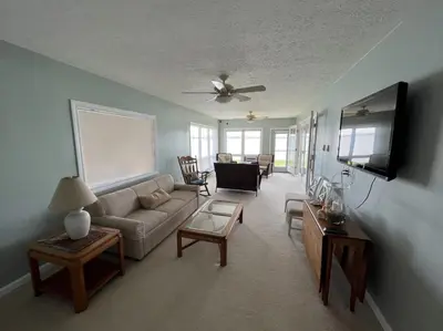 a living room with a couch and a tv at 4 Bedroom Lakefront Home with Private Beach on Cedar Point Chaussee in Sandusky