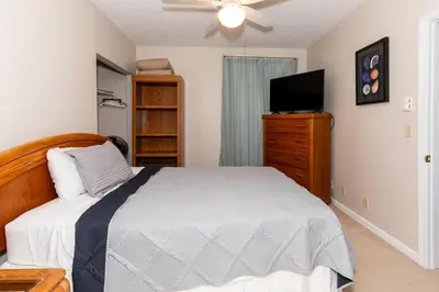 a bedroom with a bed and a flat screen tv at 4 Bedroom Lakefront Home with Private Beach on Cedar Point Chaussee in Sandusky