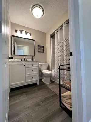 a bathroom with a sink and a toilet and a mirror at 4 Bedroom Lakefront Home with Private Beach on Cedar Point Chaussee in Sandusky