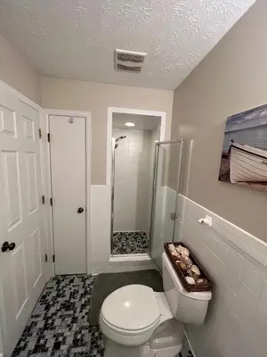 a white bathroom with a toilet and a shower at 4 Bedroom Lakefront Home with Private Beach on Cedar Point Chaussee in Sandusky