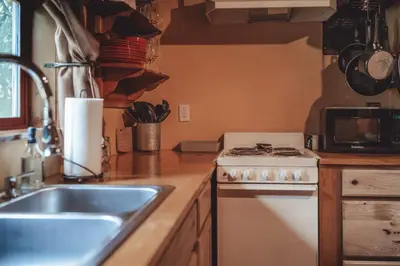 a kitchen with a sink and a stove at Great Frontier Cabin at American Heartland Cabins in Rockbridge
