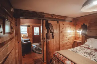 a bedroom with a bed in a wooden cabin at Great Frontier Cabin at American Heartland Cabins in Rockbridge