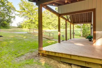 a porch of a house with a wooden deck at Serene Kentucky Cabin with Fireplace and Fire Pit! in Williamstown