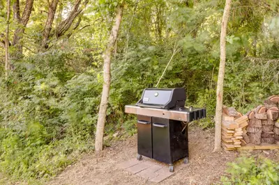 a barbecue grill with a stove top and logs at Serene Kentucky Cabin with Fireplace and Fire Pit! in Williamstown