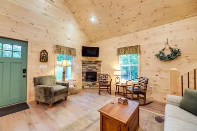 a living room with wooden walls and a fireplace at Serene Kentucky Cabin with Fireplace and Fire Pit! in Williamstown