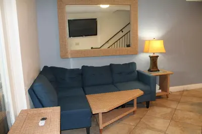 a living room with a blue couch and a mirror at Put-in-Bay Resort & Conference Center in Put-in-Bay