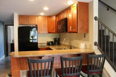a kitchen with wooden cabinets and a black refrigerator at Put-in-Bay Resort & Conference Center in Put-in-Bay