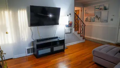 a living room with a flat screen tv on a wall at Winter Retreat 2BR, Minutes from OSU & Downtown in Columbus