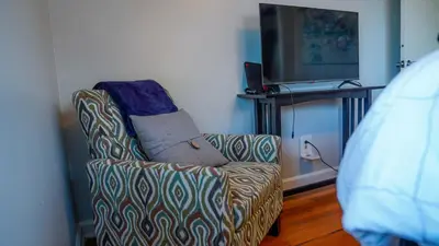 a living room with a chair and a television at Winter Retreat 2BR, Minutes from OSU & Downtown in Columbus