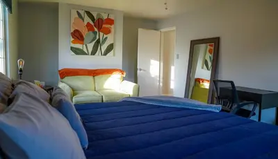 a bedroom with a blue bed and a couch at Winter Retreat 2BR, Minutes from OSU & Downtown in Columbus
