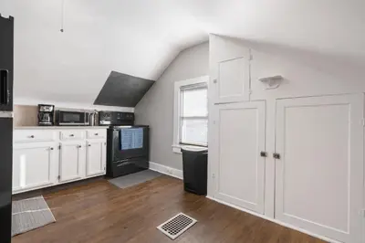 a kitchen with white cabinets and a black appliances at Apartments in the Heart of Canton in Canton