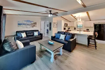 a living room with couches and a table and a kitchen at Island Club Rentals in Put-in-Bay