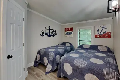 a bedroom with two beds and a window at Island Club Rentals in Put-in-Bay