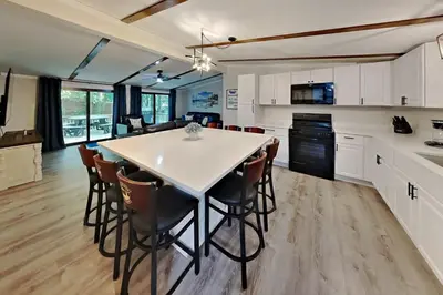 a kitchen with a large white table and chairs at Island Club Rentals in Put-in-Bay