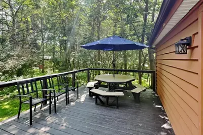 a patio with a table and chairs and an umbrella at Island Club Rentals in Put-in-Bay