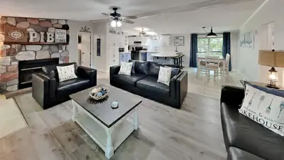 a living room with black leather furniture and a fireplace at Island Club Rentals in Put-in-Bay