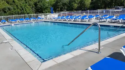 a large swimming pool with blue chairs and chairs at Put-in-Bay Condos in Put-in-Bay