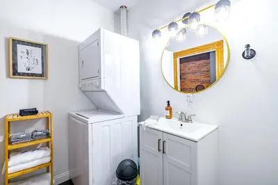 a white bathroom with a sink and a mirror at Jungle House Columbus Downtown Free Parking Sleeps 8 - Walk to Convention Center & Nationwide Arena - 1BR Short North Luxury Home - Over 5,800 Five Star Stays in Columbus