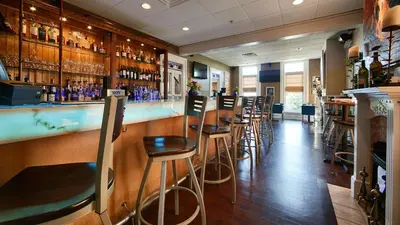 a bar with wooden bar stools in a restaurant at Best Western Plus Mentor-Cleveland Northeast in Mentor