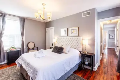 a bedroom with a large white bed and a chandelier at 2 Large Apts w Parking - Downtown Over the Rhine in Cincinnati
