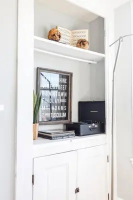 a white book shelf with a picture and a tv at 2 Large Apts w Parking - Downtown Over the Rhine in Cincinnati