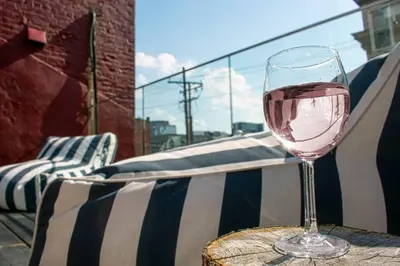 a glass of wine sitting on top of a table at Huge Parkside Retreat - Private Roof Decks in Cincinnati