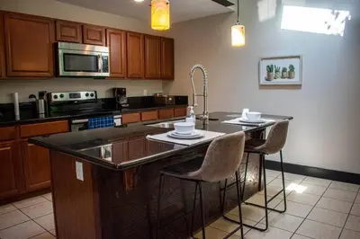 a kitchen with a island with bar stools in it at Huge Parkside Retreat - Private Roof Decks in Cincinnati