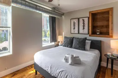 a bedroom with a bed with two towels on it at Broadway Suites - Stunning Downtown Condos in Cincinnati