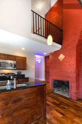 a kitchen with a brick wall and a fireplace at Broadway Suites - Stunning Downtown Condos in Cincinnati