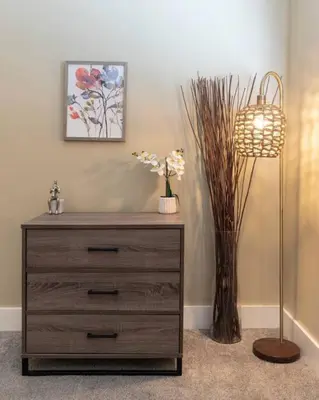 a dresser with a lamp and a vase with flowers at Broadway Suites - Stunning Downtown Condos in Cincinnati