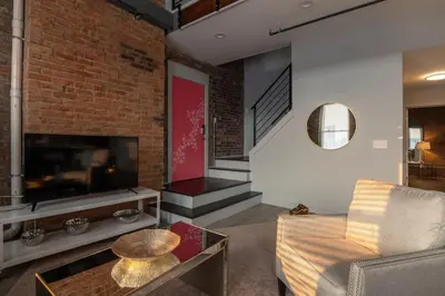 a living room with a couch and a tv at Entire Historic Building Sleeps 30 in Cincinnati