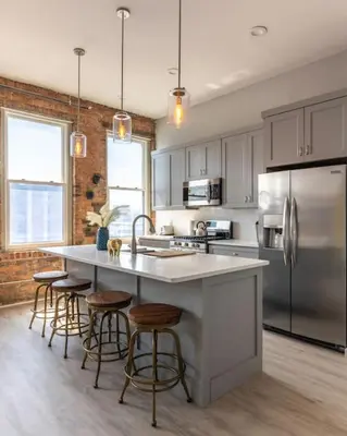 a kitchen with a large white island with bar stools at Entire Historic Building Sleeps 30 in Cincinnati